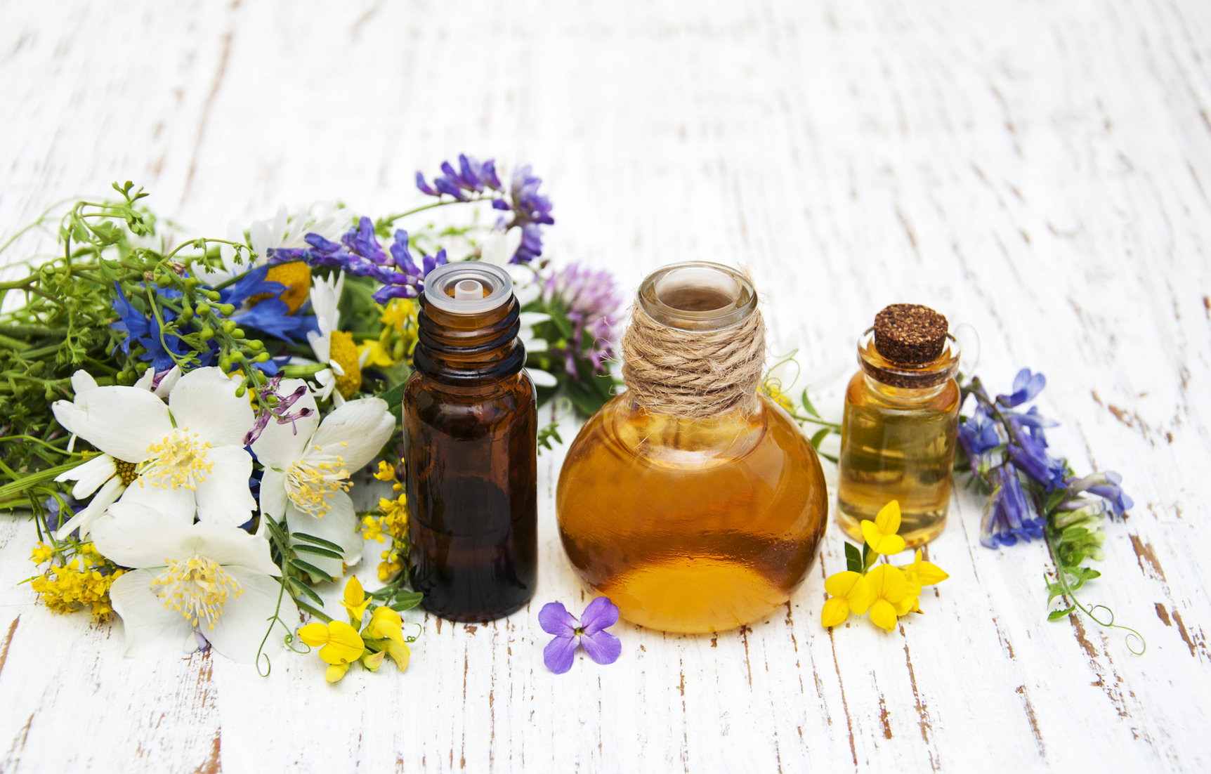 Nature oil with wildflowers on a old wooden background